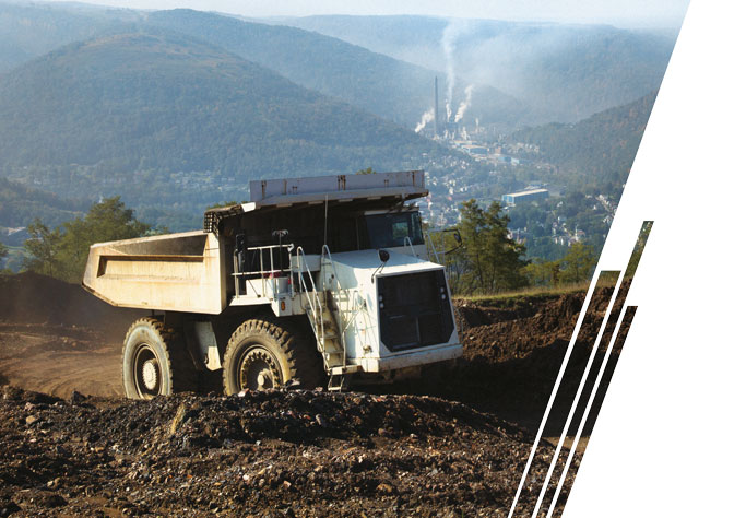 A white mining dump climbs a hill in the mountains.