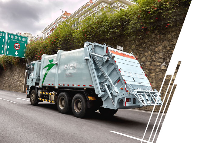 A bluish gray Asian refuse vehicle travels along a city highway.