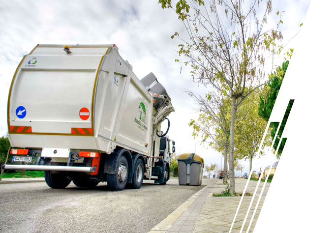 A white European refuse vehicle picks up a gray trash bin and empties it over the top of the vehicle.